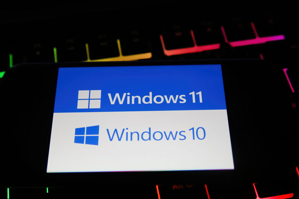 viersen, germany january 9. 2022: closeup of mobile phone with logo lettering of windows 10 and 11 operating system on computer keyboard