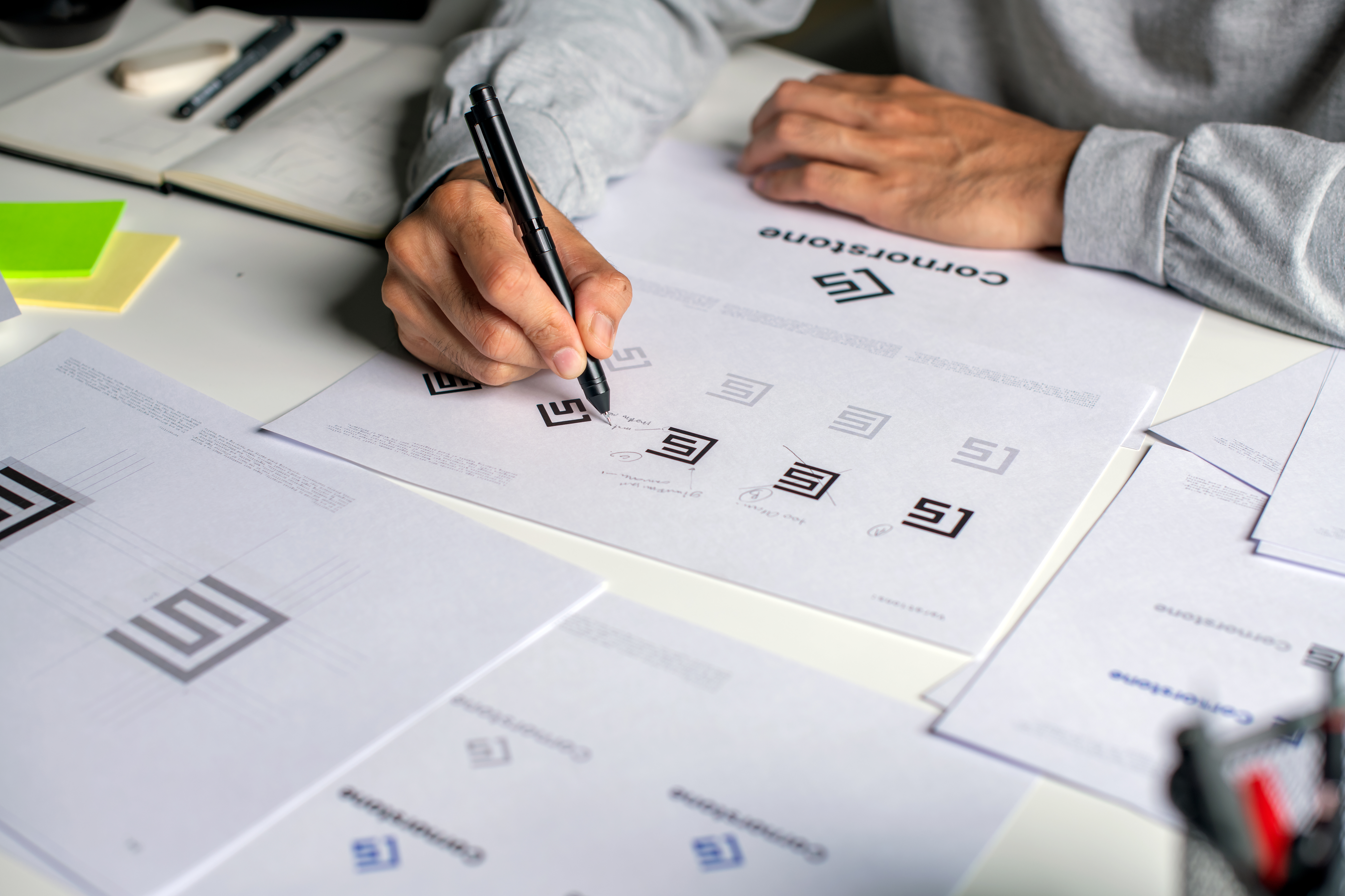 close up shot of a graphic designer making notes on logo designs and showcasing the corporate identity and logo design process.